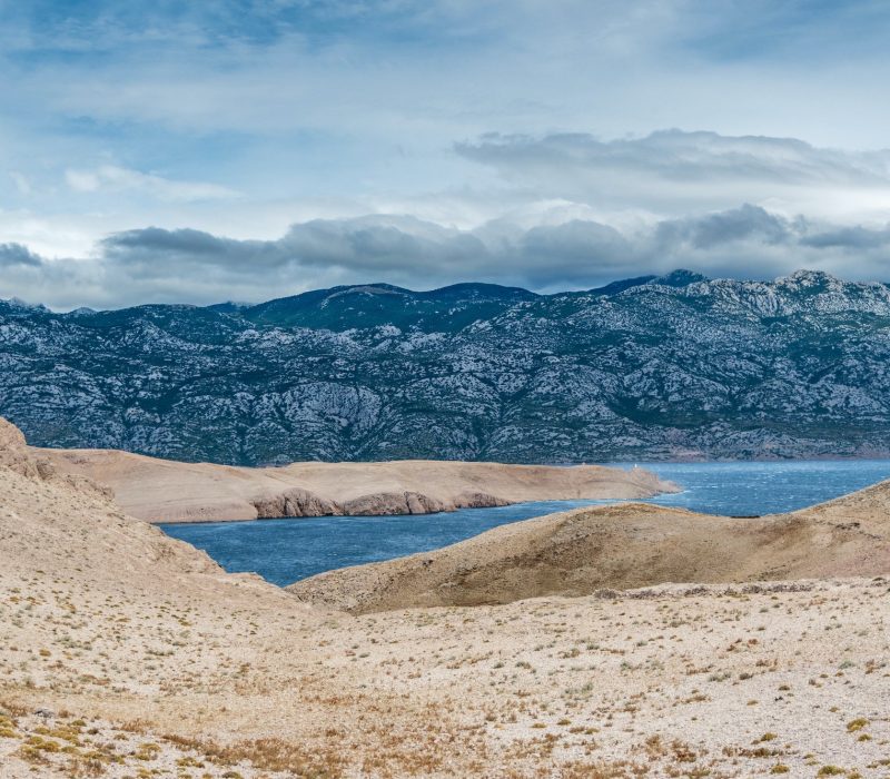 Arid landscape with amazing sky and clouds. Sea, seascape, coastline, mountains. Pag, Croatia.
